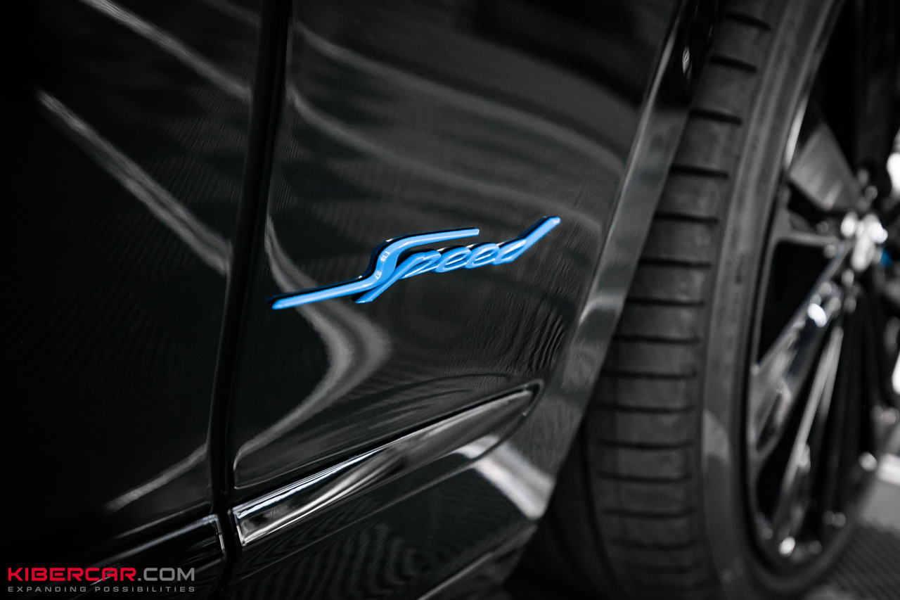 Голубой шильдик Speed на черном крыле Bentley Flying Spur, крупный план