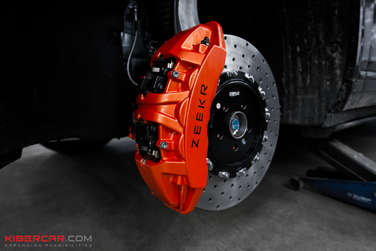 Крупный план оранжевого суппорта Brembo с надписью ZEEKR и перфорированного диска на передней оси Zeekr 9X